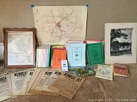 Overview photo showing a collection of Westborough memorabilia spread out on a surface. Includes maps, postcards, brochures, flyers and several vintage paper items.