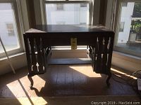 Front view of antique wooden desk showing single drawer and bookshelf sides with cabriole legs.