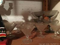 Frosted stemmed glass dessert or cocktail cups arranged on a shelf.