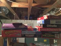 Photo showing stacked board game boxes including Shark Attack, Battleship, Sparkle Sprograph, and Abalone