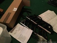 Photo showing black BMW ski rack components laid out with instruction manual and original packaging box.