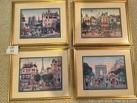 Full view of all four framed Parisian prints arranged on carpet floor, illustrating relative size and frame style.