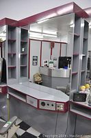 Full view of the wall-mounted hair dressing station showing mirror, counter, drawers, and open shelves.