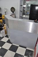 Front view showing the metal silver raised counter and panel design of the reception desk unit.
