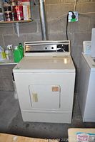 Full front view of Inglis Liberator Plus dryer with vent pipe and surrounding laundry items.