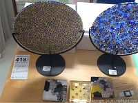 Two round Murano dishes on stands with four paperweights on table
