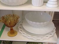 Milk glass trays and amber Fenton hobnail pedestal bowl on shelf