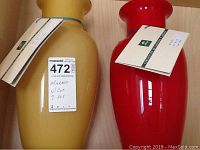 Two Murano glass vases; one yellow opaque and one red, both with COA tags attached