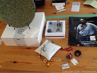 Murano plate on black stand with box and assorted Murano glass jewelry on the table including rings, bracelet, earrings.