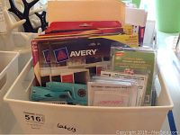 Top view of a plastic container filled with assorted label packs and kits, including Avery brand packages.