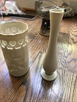Ceramic white vase with floral cut-outs and tall cream-colored slender vase