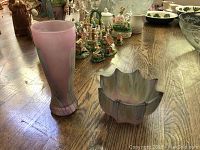 Photo of pink floral vase and multicolored art glass dish on wooden table