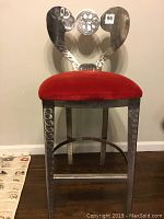 Front view of the stainless steel chair with red velvet seat