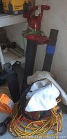 Two Toro leaf blowers, one red Toro Ultra Blower Vac with metal impeller secured with green strap, shown with multiple extension cords and accessories around them.