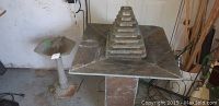 Wide view showing the garden fountain with pyramid centerpiece and birdbath pedestal together indoors.
