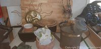 Overall lot view showing sun wall decor, various flower pots and containers