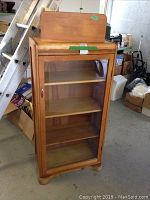Front view of antique wooden bookcase with glass door and shelves inside
