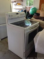 Front and side view of white Kenmore range in garage setting