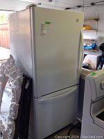 Front view of white Kenmore refrigerator with bottom freezer compartment