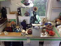 Overview of the table displaying various decorative items, incense holders, and boxed game, along with tabletop water fountains.