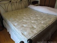 Full view of king size mattress with quilted floral pattern and bed frame visible.