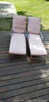 Two chaise loungers with brown cushions on wooden deck, showing overall condition.