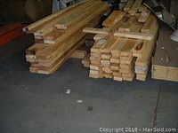 Two stacks of various length spruce boards on concrete floor