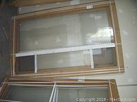 Two windows stacked vertically in cardboard packaging against a wall.