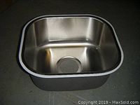 Close-up of one single bowl stainless steel sink showing brushed finish and drain hole.