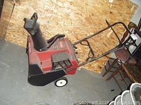 Full side view of Toro CCR 2450 snowblower showing red and black body, wheels, and handle