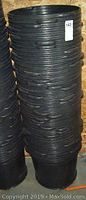 Stack of black plastic plant buckets