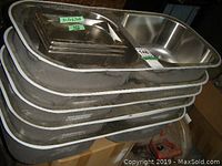 Stack of 5 stainless steel double bowl sinks with 3 smaller stainless steel containers on top, showing metal finish and dimensions sticker.