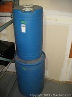 Two blue plastic barrels stacked, showing general size and condition