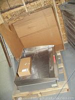 Electric griddle on wooden pallet with open cardboard packaging