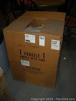 Cardboard shipping box labeled Fetco with “Fragile Handle With Care” marking.
