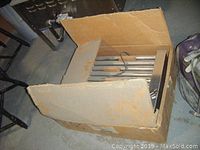 Cardboard box containing stainless steel roller grill components