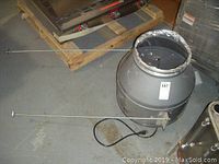 Overall view of fan housing with support rods and power cord on floor