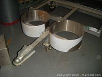 Tongue assembly with hitch coupler, swiveling caster wheel and two circular propane tank rings mounted on galvanized steel frame