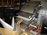 Two skids loaded with stacked large metal reflector hoods, assorted wiring and bulb boxes.