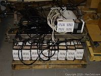Front view of pallet showing eight ballasts on bottom and one on top with cables