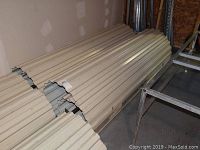 Pair of rolled-up off-white slatted metal doors seen on the floor