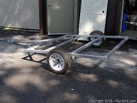 Angled front-side view showing full trailer frame, box deck and wheels