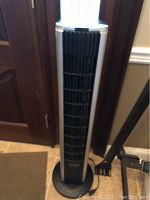 Full view of tall Bionaire tower fan showing front grille and round base.