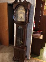 Full view of the tall wooden grandmother clock showing overall condition, style and finish.