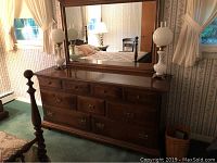 Full view of the Ethan Allen triple dresser with attached mirror in a bedroom setting.