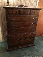 Front view of the Ethan Allen solid wood chest of drawers showing multiple drawers with wooden knobs and brass handles.