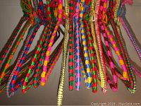 Top-down view showing multiple wire hangers wrapped in various colorful crochet yarn patterns hanging together.