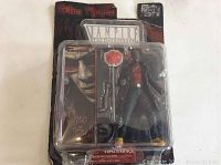 Packaged Theo Bell action figure with gun, hat, and sign visible from front packaging