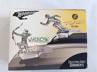 Box front showing chrome hood ornaments of The Flash and Arrow TV series characters, labeled collectibles.