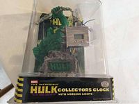 Front view of Marvel The Incredible Hulk Collectors Clock in original plastic display packaging showing the Hulk figure, digital clock, and labeling.